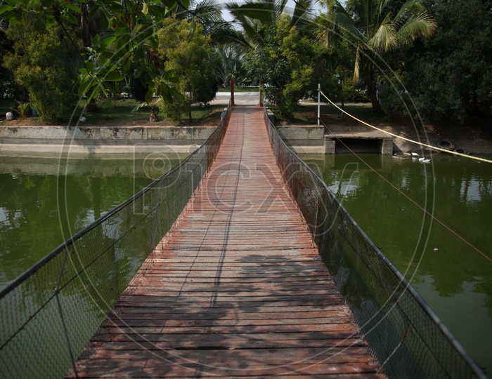 A small wooden bridge with mesh reeling over a canal