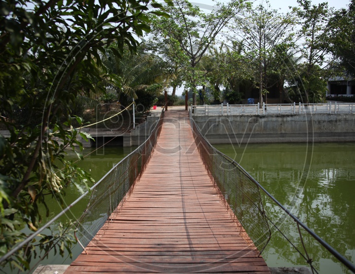 A small wooden bridge with mesh reeling over a canal
