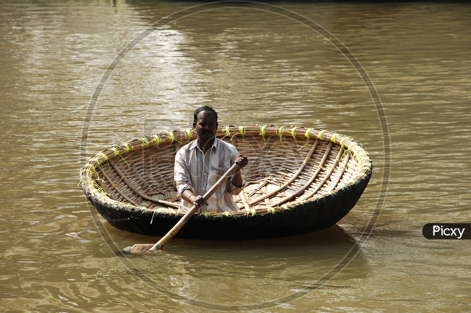 A person moving in a coracle on the river