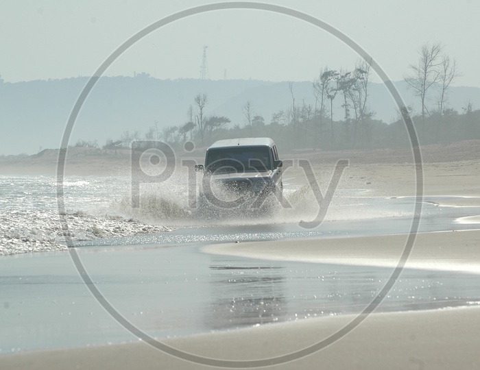 A Car Riding through The Beach Waves