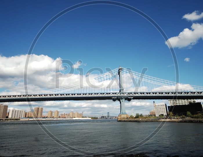 Manhattan bridge with clouds in the sky and Williamsburg bridge in the background
