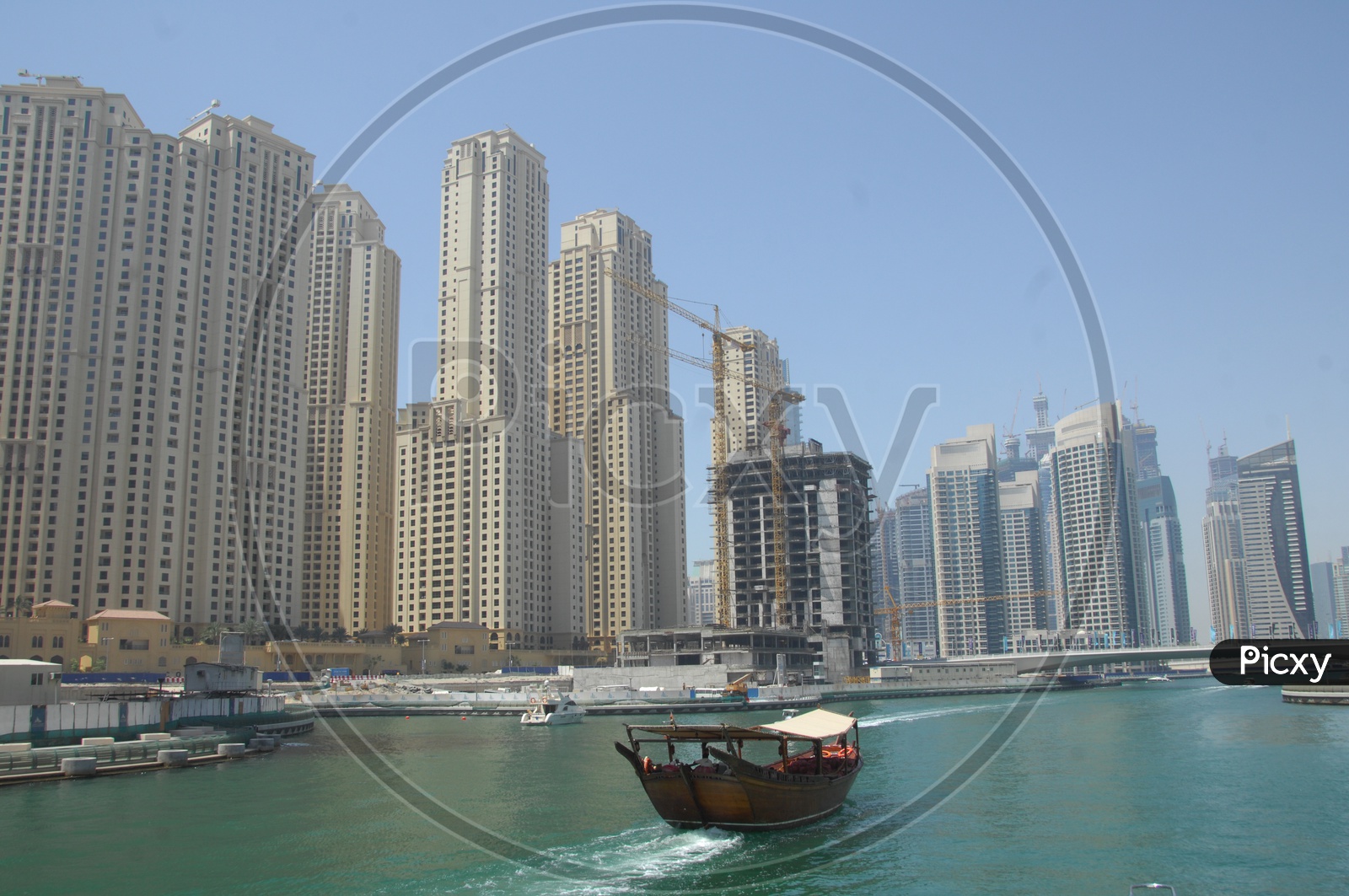 View of the city from the beach - Blue waters, tall buildings and a boat