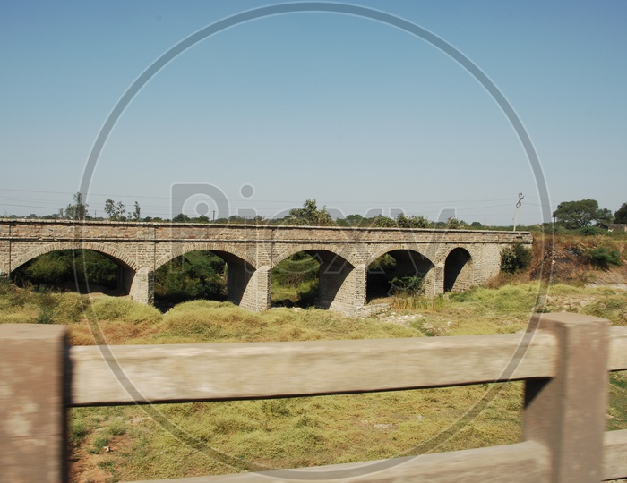 View of old ancient arch shaped bridge from the overpass