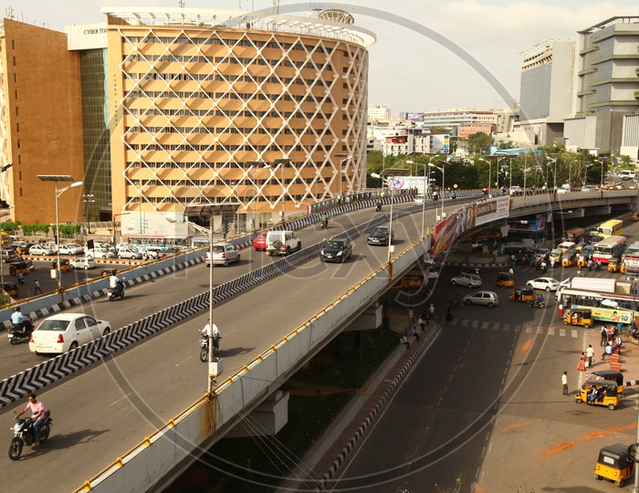 View of the Cyber Towers building in Hyderabad with vehicles moving in the foreground