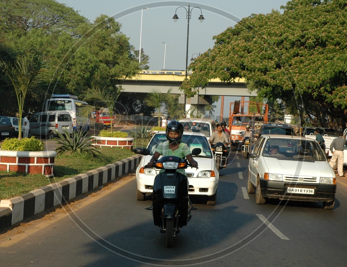 Moving traffic on a main road passing under the Mandovi bridge