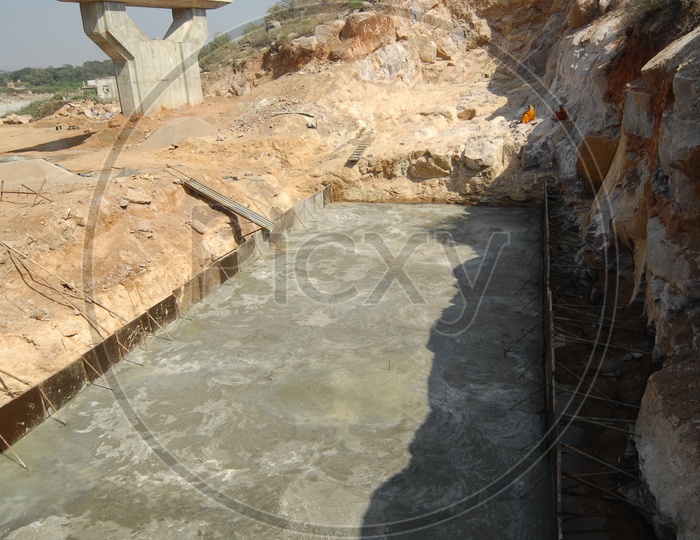 Cement work alongside the construction of bridge during daylight