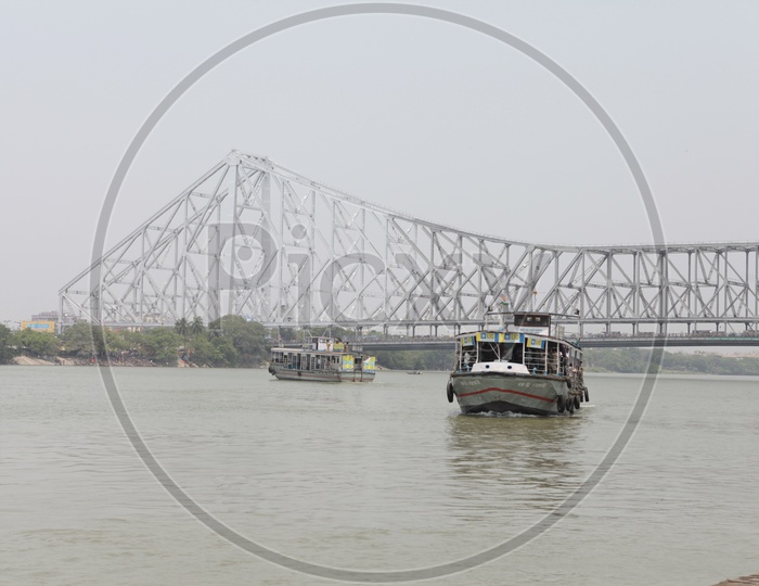 Long view of Howrah bridge and boats in the river