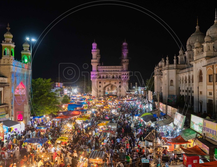 Crowd in street bazaar during the night with charminar in background