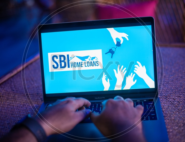 Indian Man Accessing The SBI Home Loans Portal In Laptop