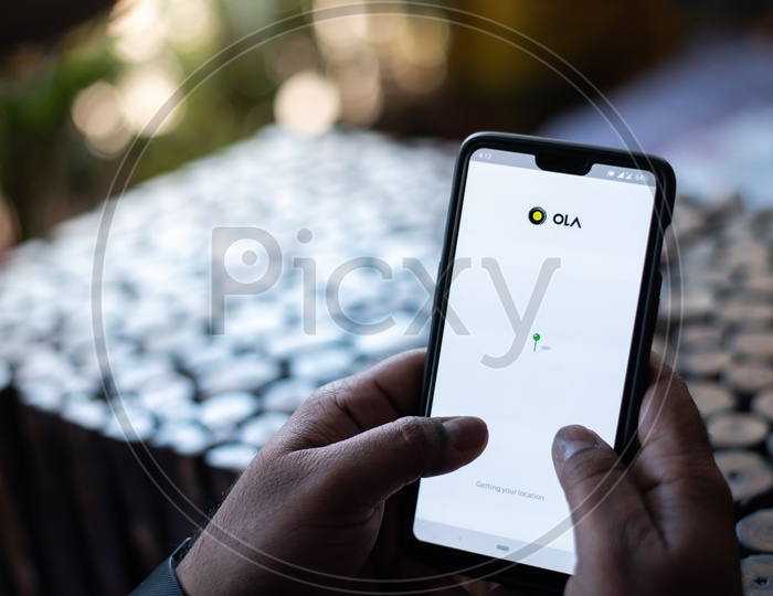 Indian Man Using OLA App for Car Taxi Booking in Smart Phone