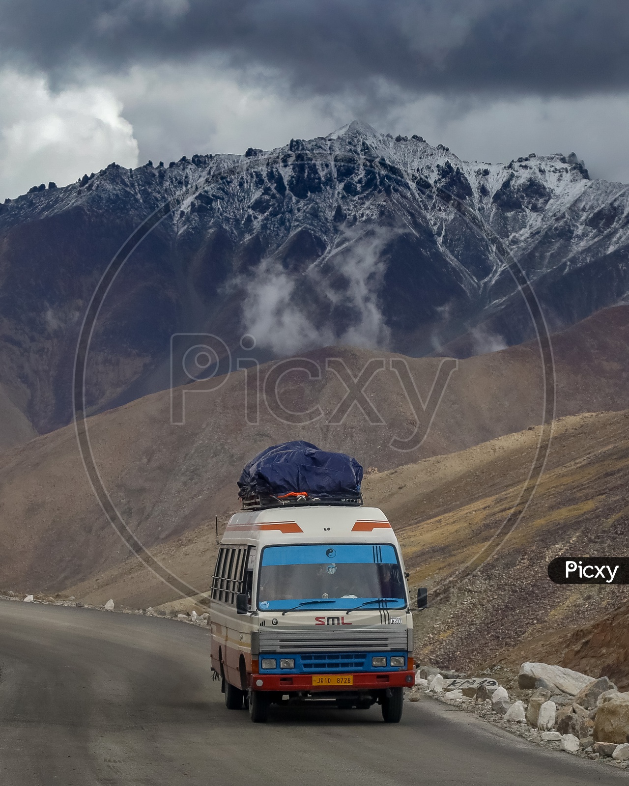 Mini van moving through the roadway amidst of mountains