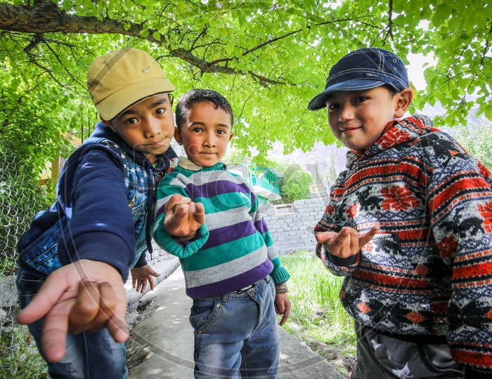 Three Himalayan boys posing like the Spiderman