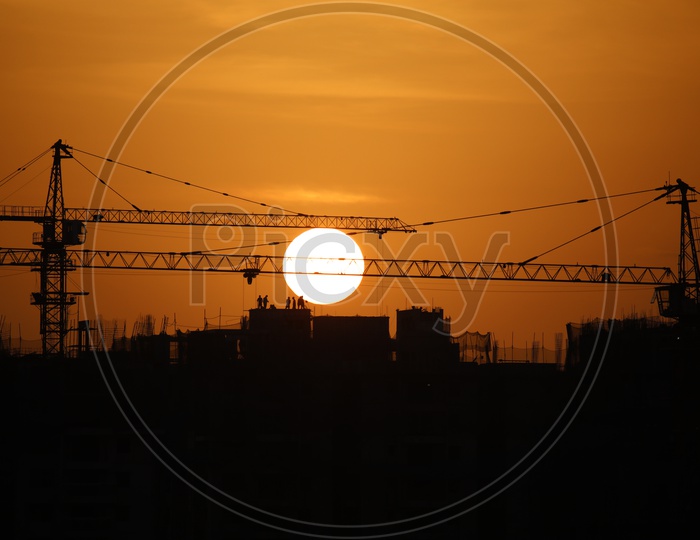 Silhouette of Workers on   High rise Buildings  Over  Sunset