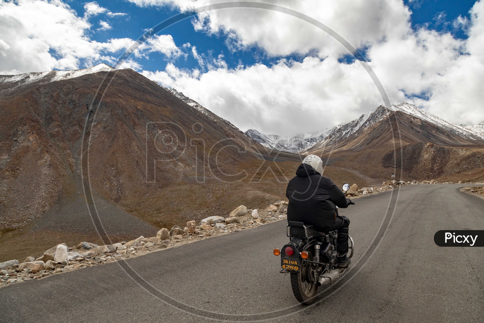 Royal Enfield Rider travelling on the roadway by the mountains