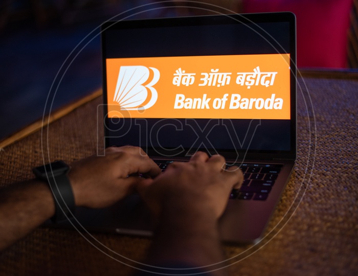 Indian Youth Accessing Online Banking Of  Bank Of Baroda   in Laptop