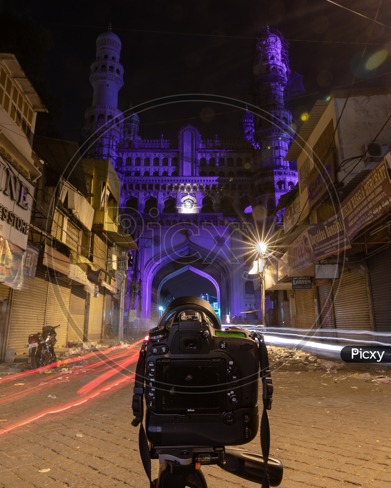 Camera mounted to a tripod shooting the light trails by the charminar
