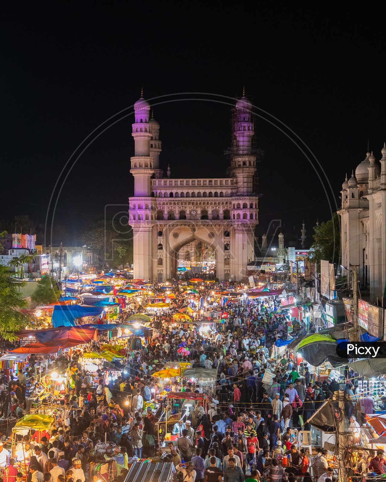 Crowd in street bazaar alongside the Charminar during night