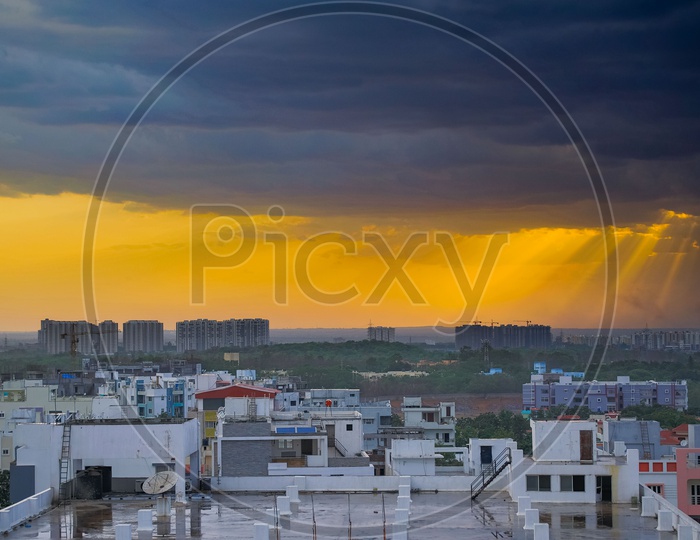 Hyderabad City Scape With high Rise Construction Buildings And Dark Clouds on Golden Hour Sky In Background