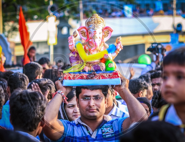 Man Carrying Lord Ganapathi or Ganesh Idol