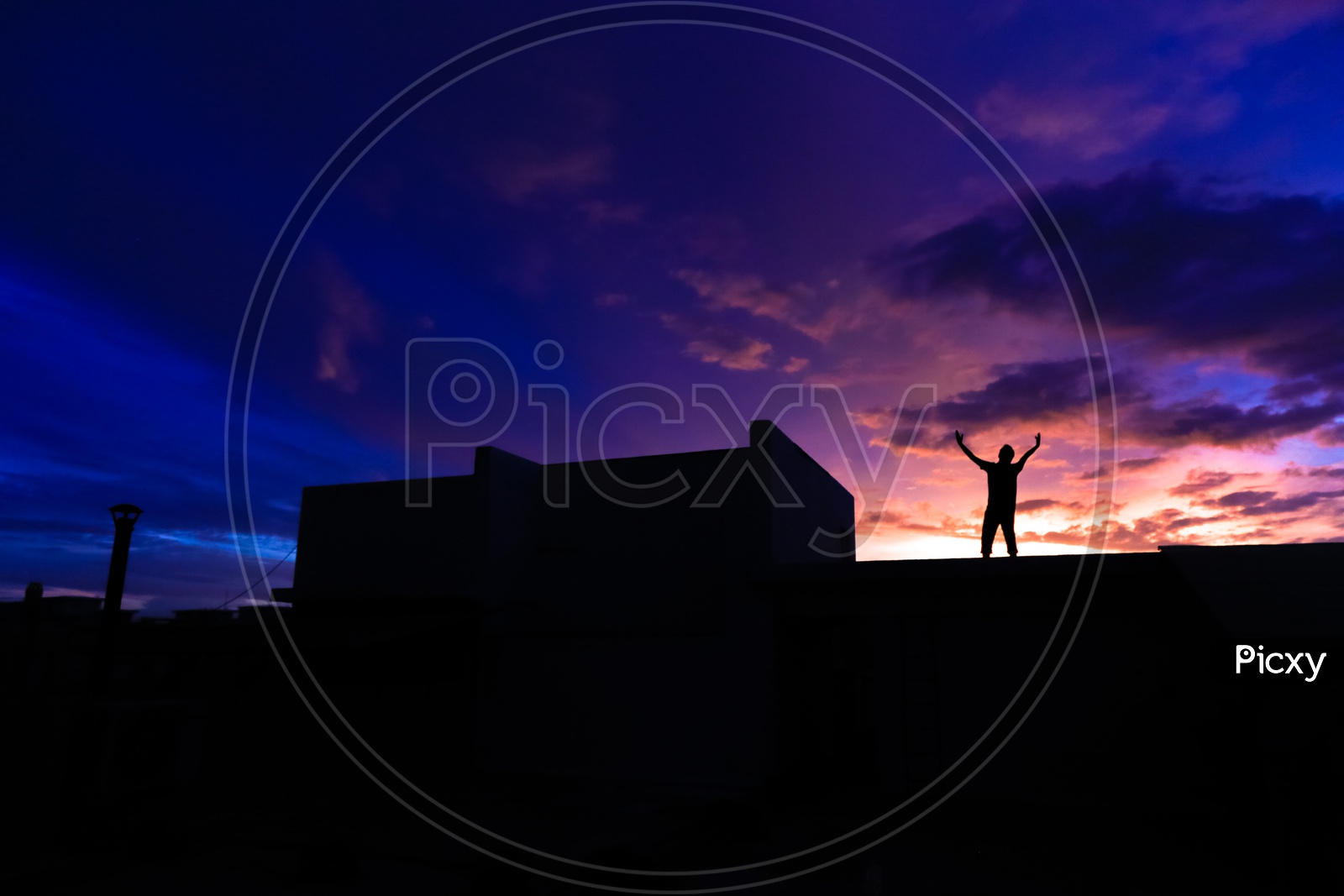 Silhouette of a Joyful Man Wide Spread his Arms over  a golden Hour Sky