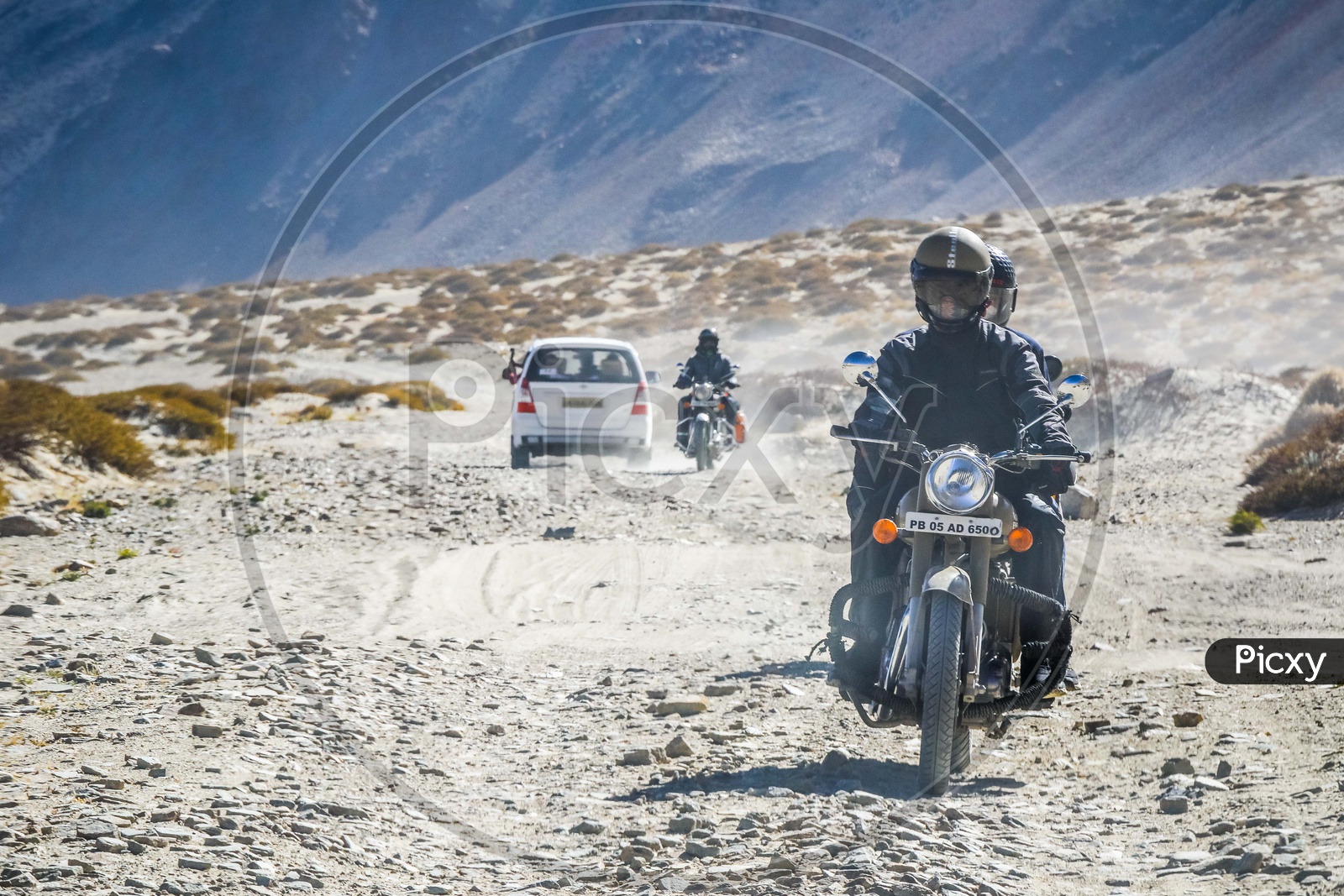 Riders riding motorcycle on the sand dunes alongside the Nubra Valley
