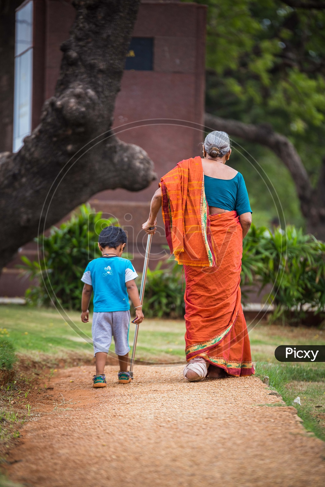 An Old Woman  Walking along With Her Grand Child in  a Park