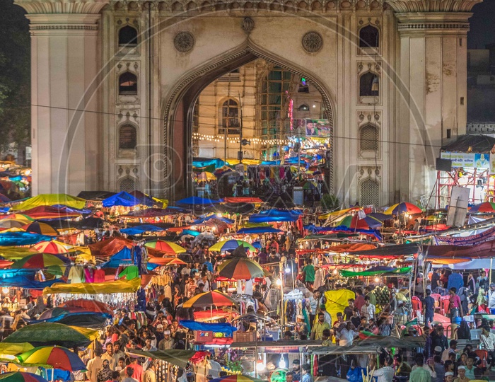 Crowd during the night in street bazaar with charminar in background