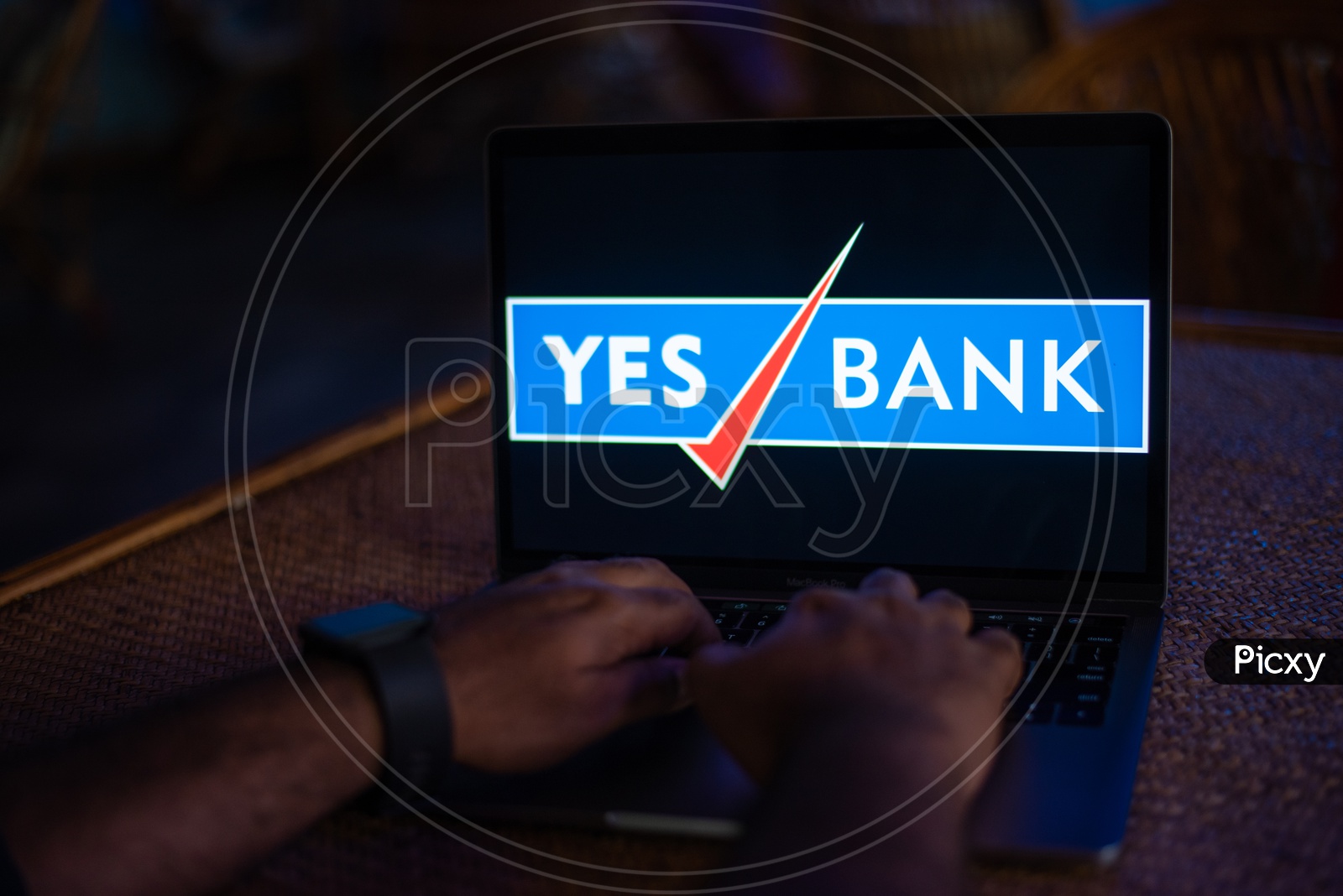 Indian Youth Accessing Online Banking Of YES  BANK  in Laptop