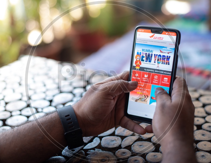 Indian Man Using AIR INDIA App For Booking Flight tickets Online In Smart Phone