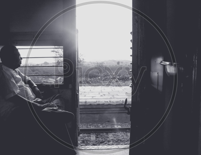 Monochrome of a man Sitting at a Train door