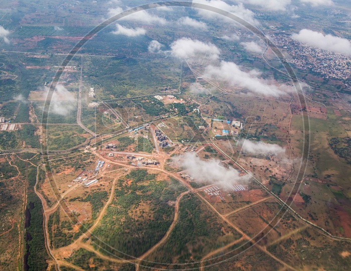 Aerial View Of City Scape And Agricultural Fields  from Flight With Cotton Clouds