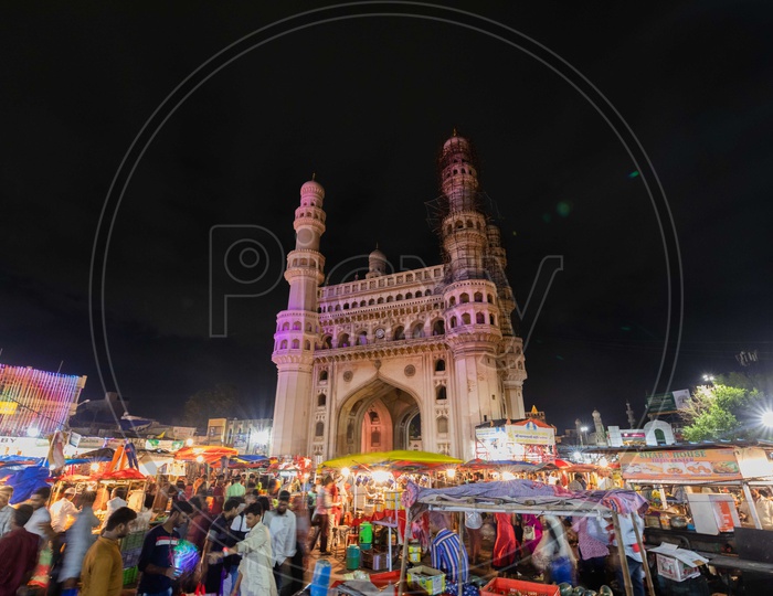 Bazaar street crowd alongside the Charminar during the night