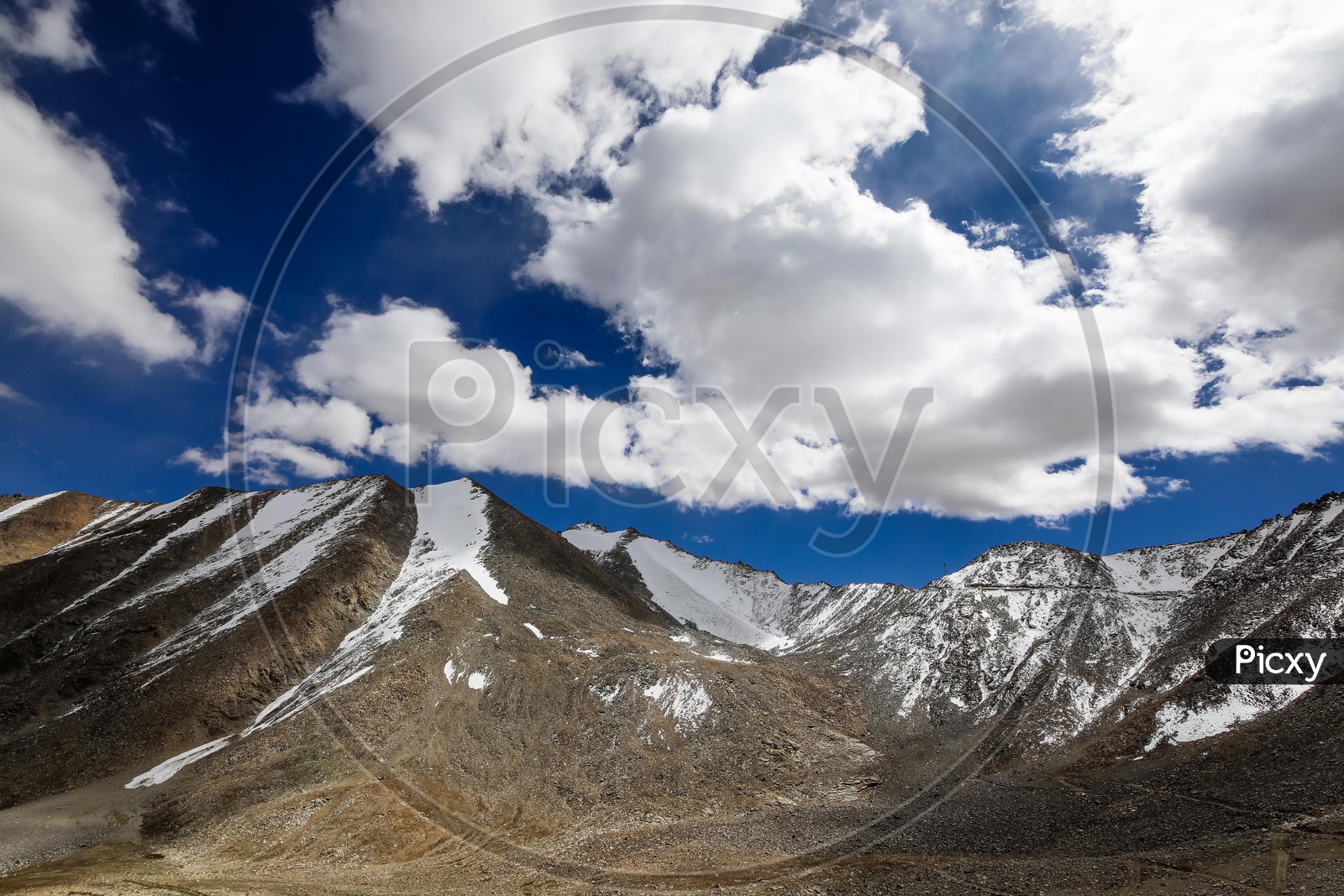 Landscape of snow capped mountains along with the clouds