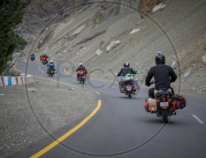 Group of travellers riding motorcycles on the highway by the hills