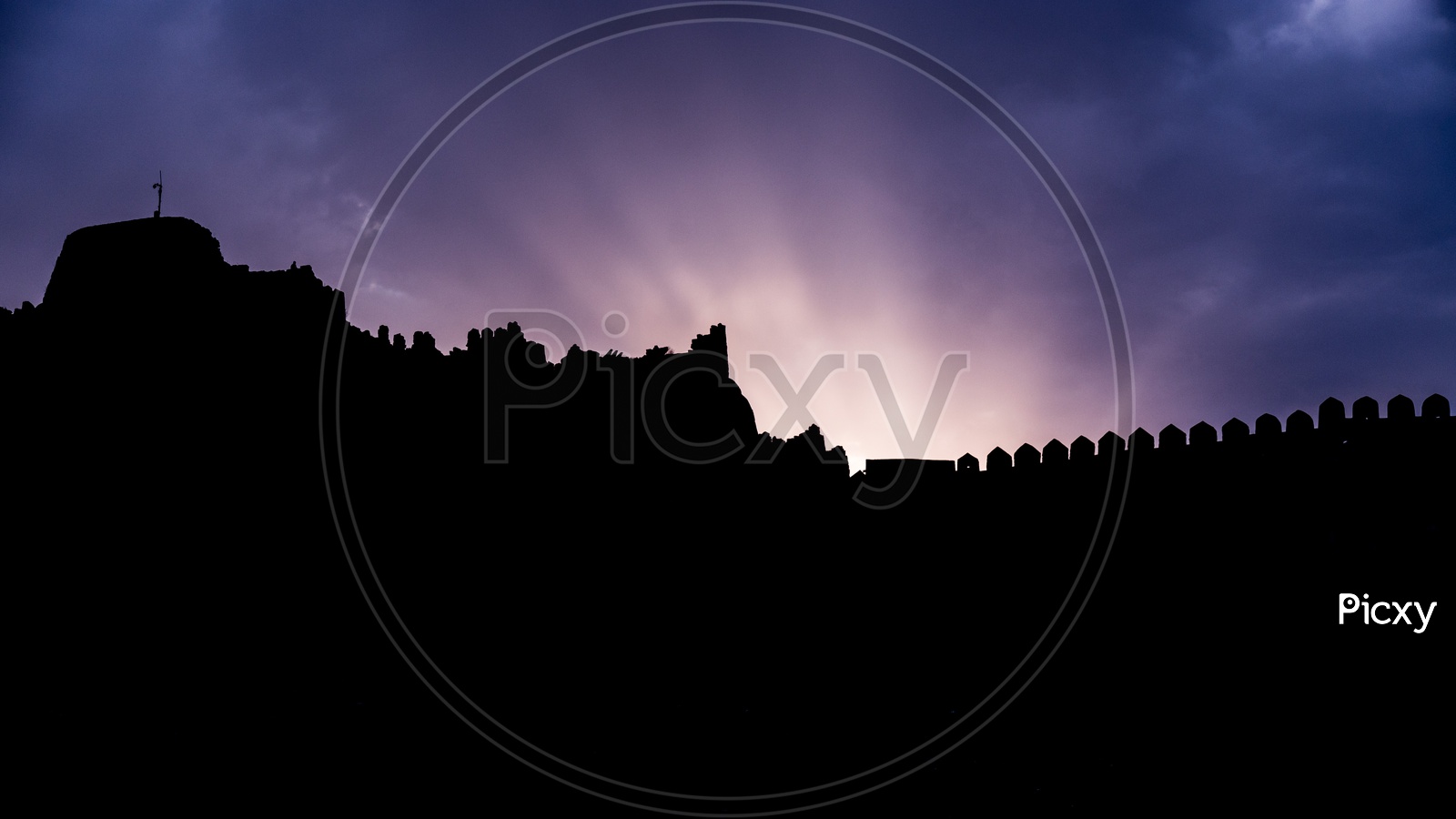 Silhouette Of  Golconda Fort Walls Over a Blue Hour Sky In Background