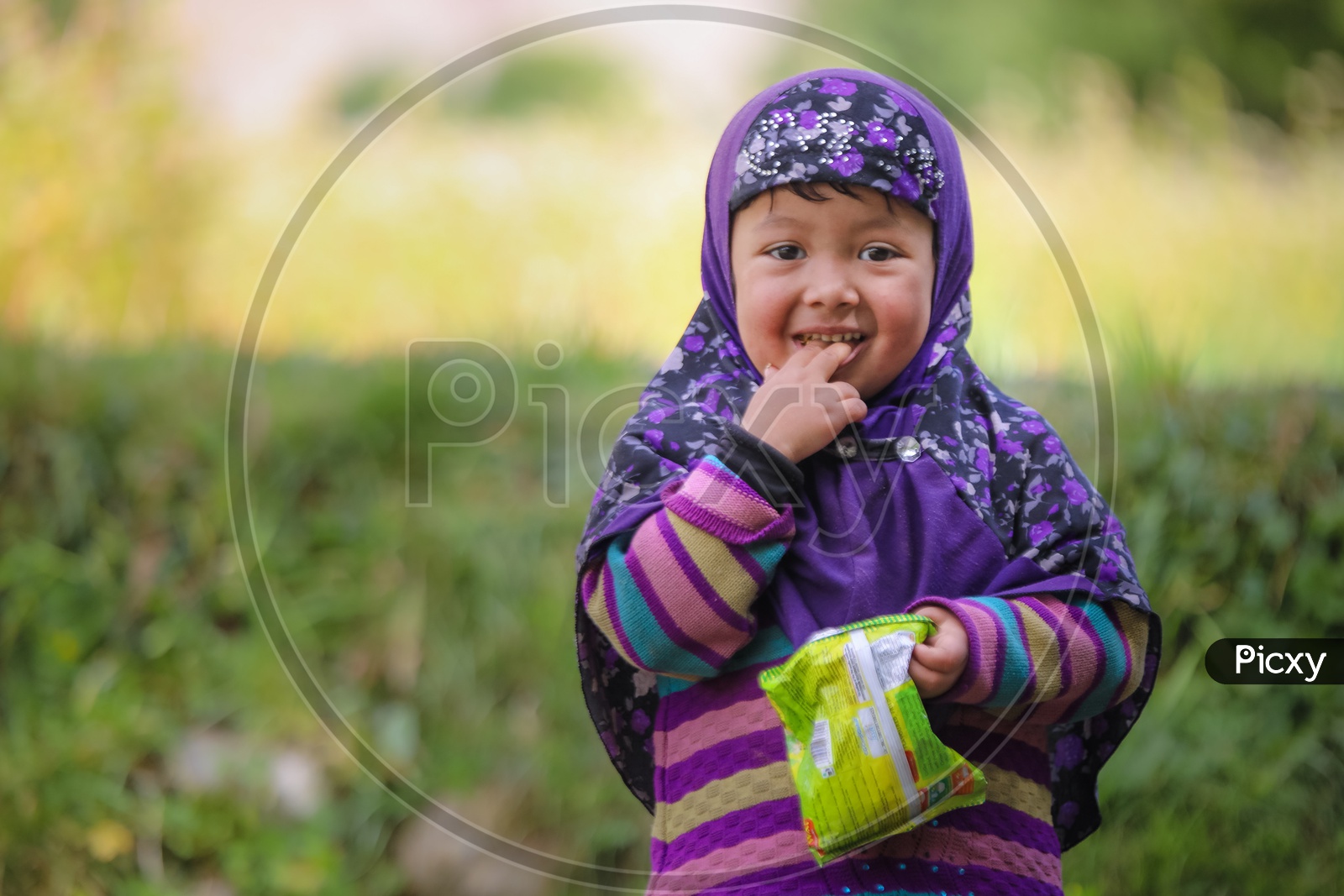 Portrait of a Himalayan girl kid eating chips