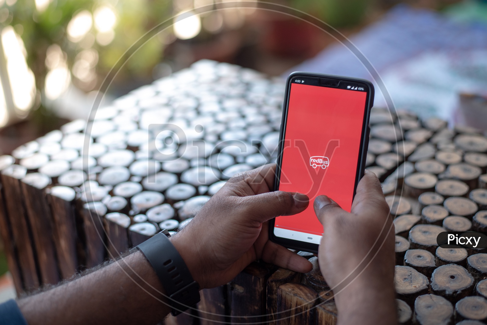 Indian Man Accessing Red Bus App For Boooking Bus Tickets Online in smart Phone