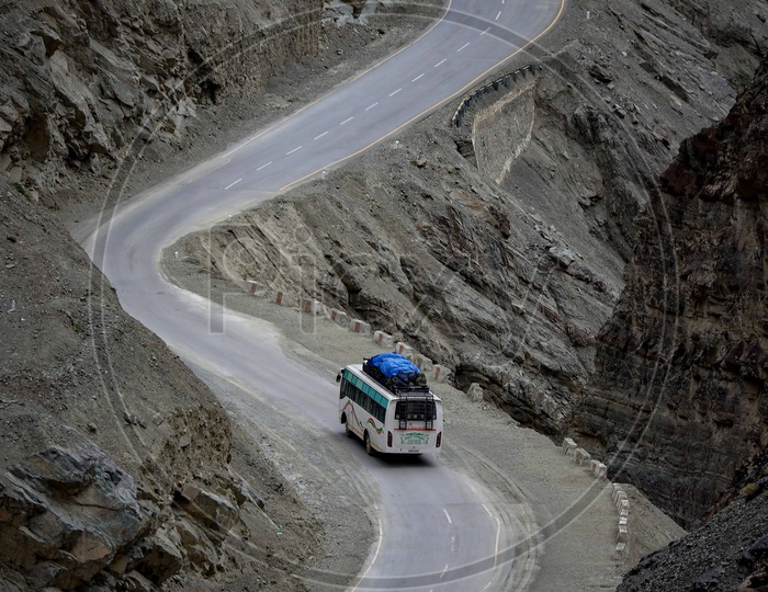 Tourist bus moving on the curvature of the roadway by the moutains