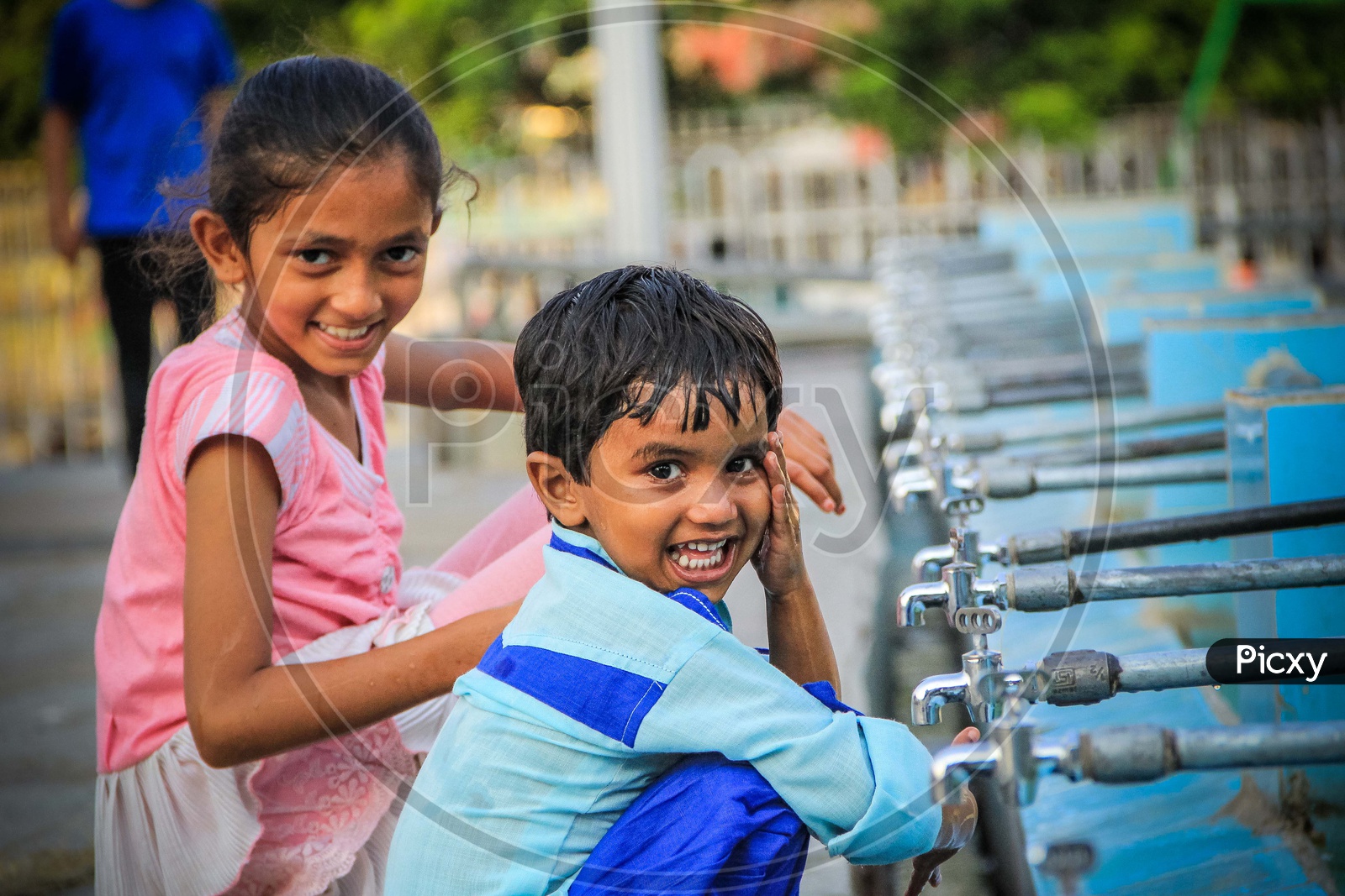 Portrait Of A Siblings At A Water Pond With Taps And smiling