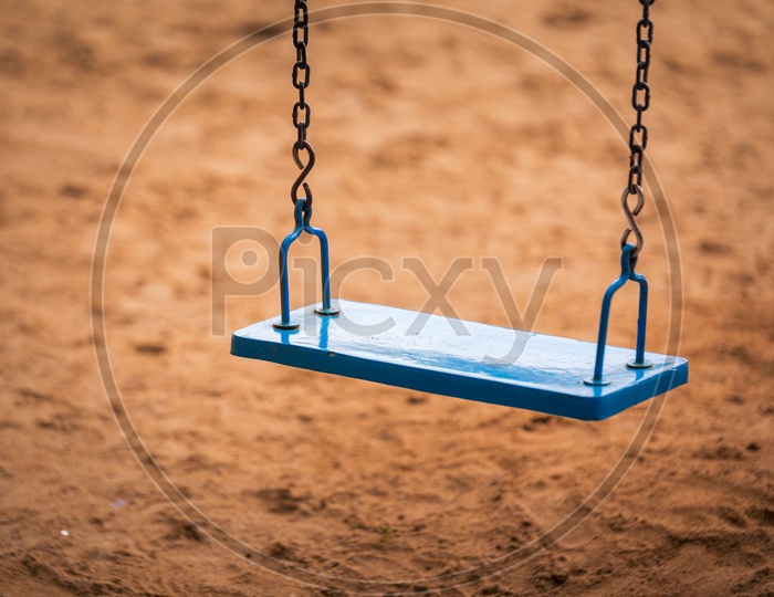A Wooden Swing With Iron Chain in a Park