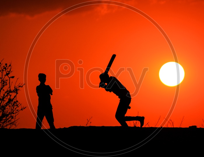 Street Kids Playing Cricket and Sunset in Background