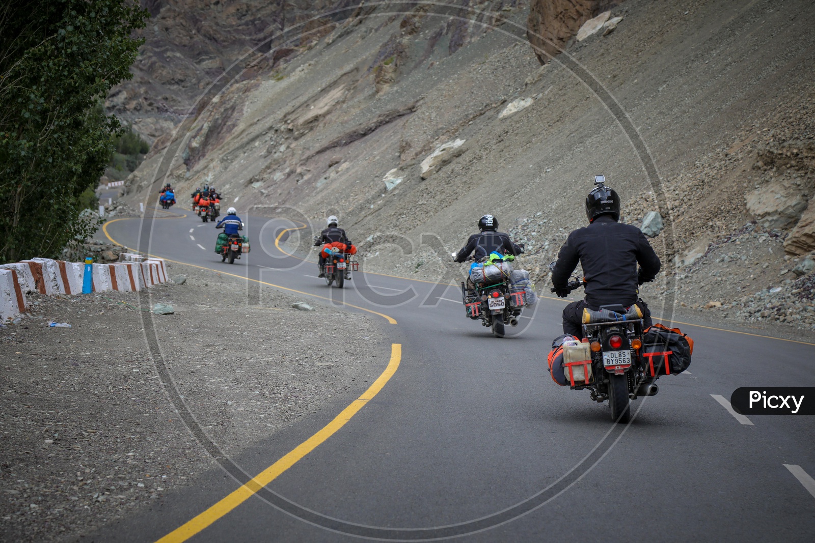 Group of travellers riding motorcycles on the highway by the hills