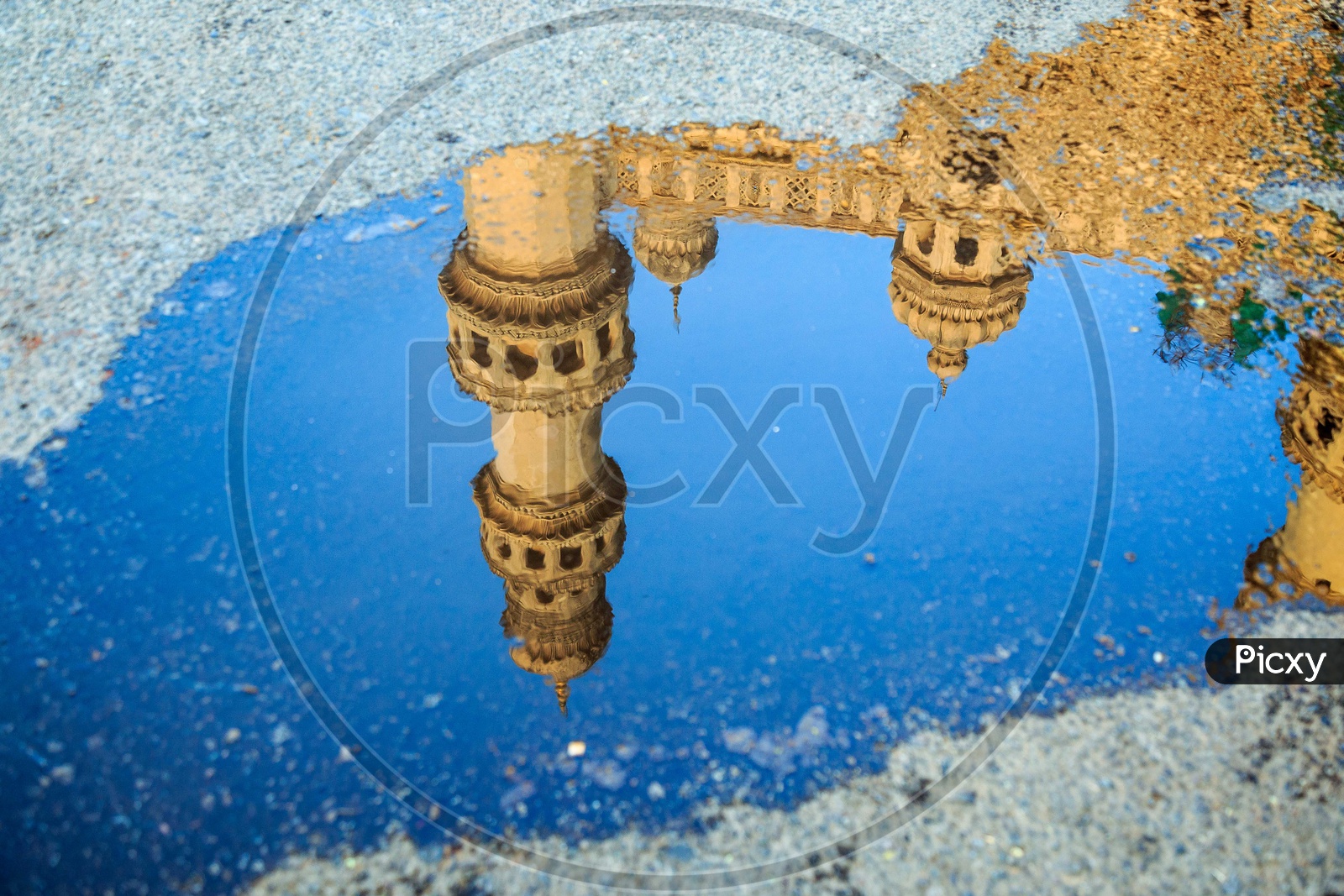 Reflection of Charminar on the stagnant water of a Road