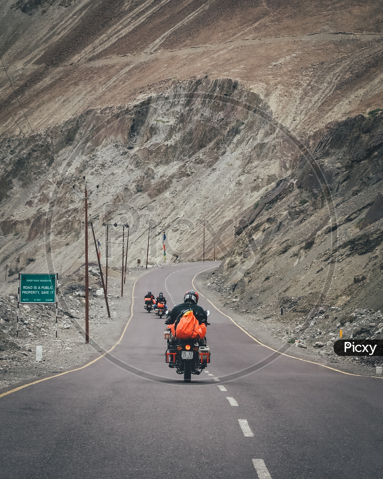 Group of travellers riding motorcycles on the highway through the hills