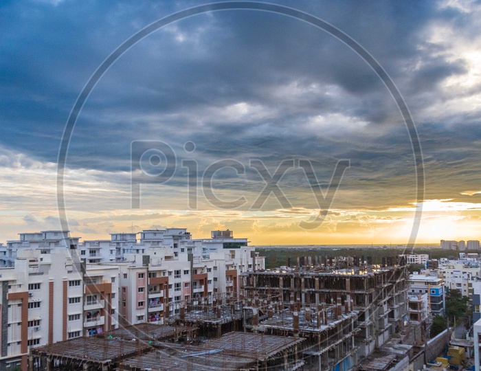Aerial View Of Construction Buildings and High Rise Apartments with Dark Clouds In Sky