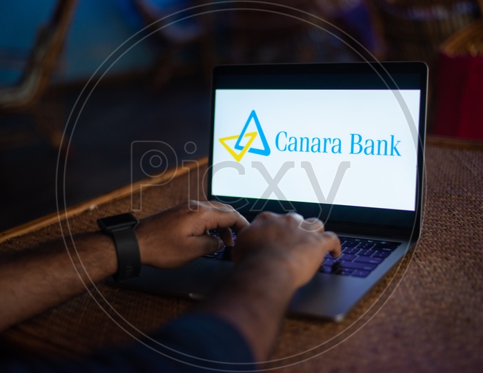 Indian Youth Accessing Online Banking Of Canara  BANK  in Laptop