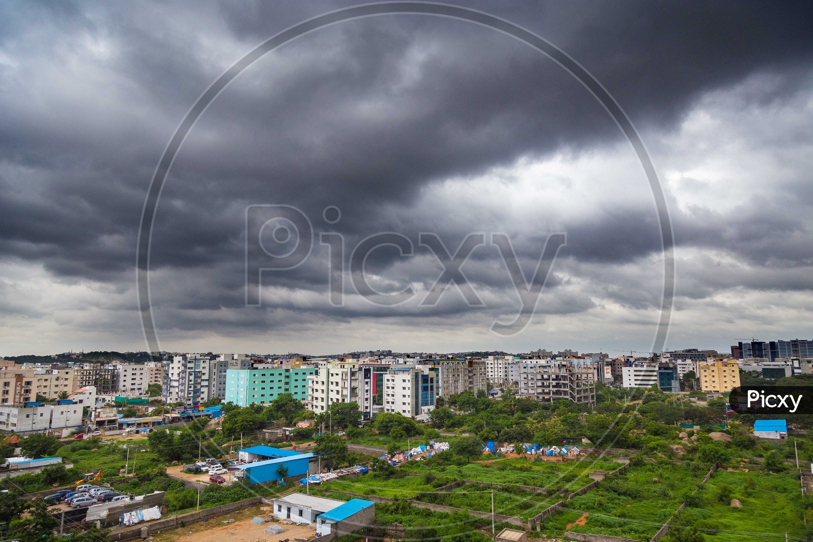 City Scape View With Apartments And Dark Black Clouds In Sky