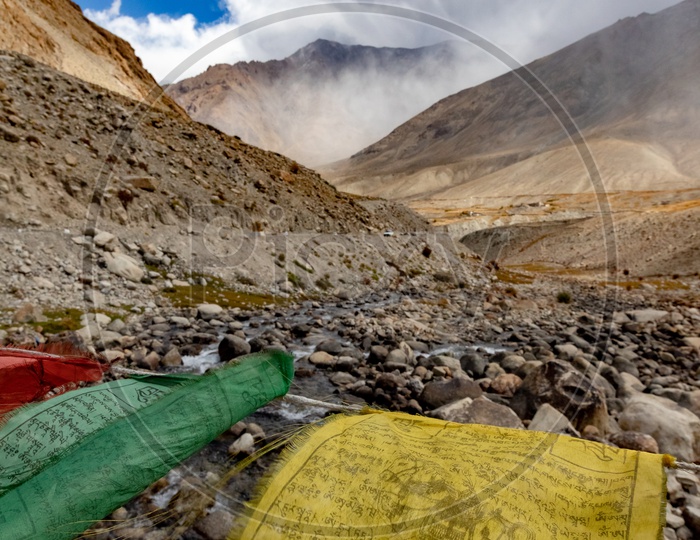 Waving prayer flags alongside the mountains covered with mist and clouds
