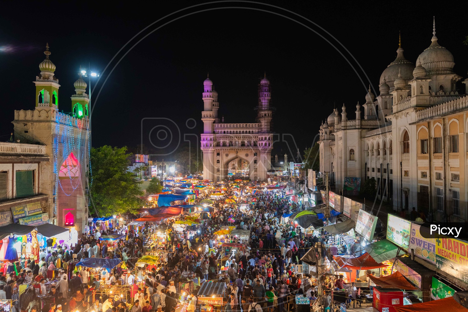 Crowd in street bazaar during the night with charminar in background