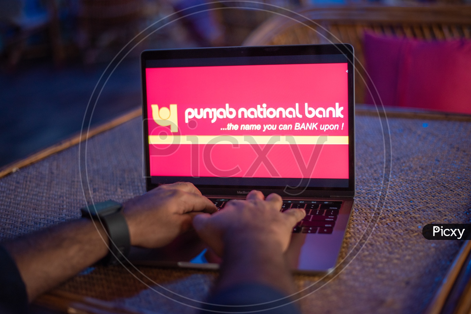 Indian Man Accessing Punjab National Bank Online Portal In Laptop